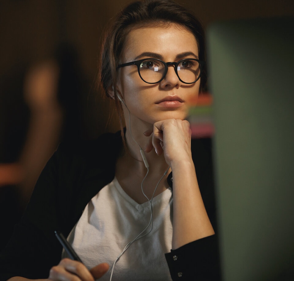 Head Banner describing Business Woman in glasses focused on her workstation.