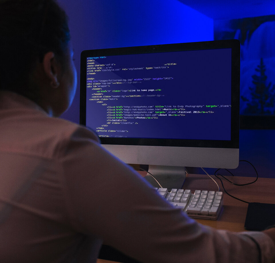 Head Banner describing a woman sitting in the dark coding a website.